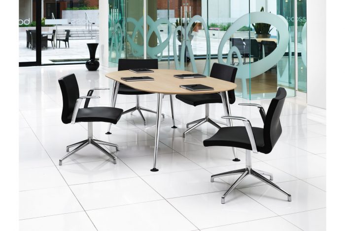 modern table with light wood top and black chairs