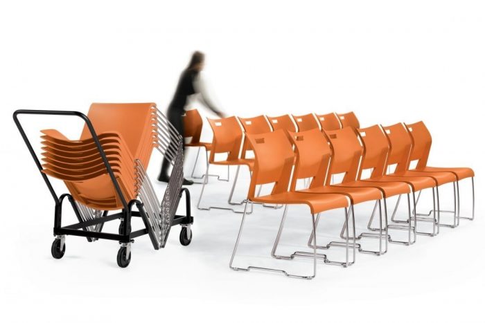 Woman using high-density stacking chair dolly to move orange duet stacking chairs