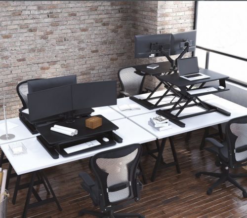 standing desk on top of modern table desks in a loft workspace
