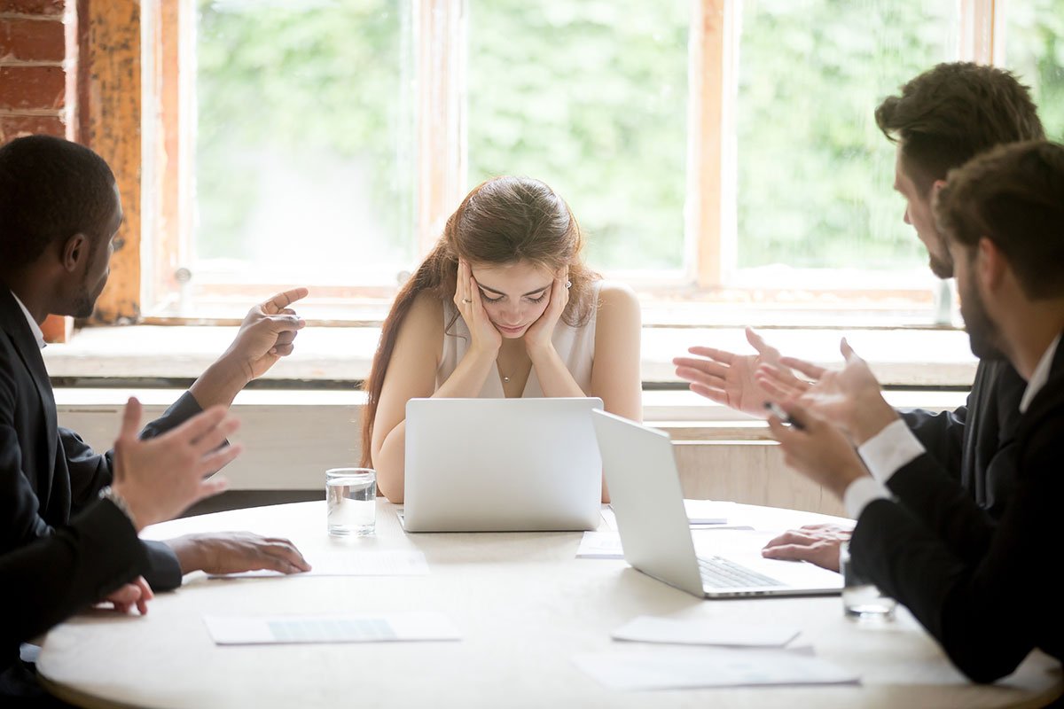 woman at the head of a meeting that looks stressed