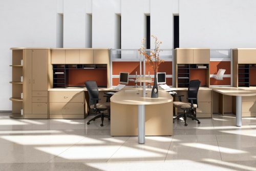 Studio photography, showing two Alero chairs placed on the inner corner of two workstations. Each 1961 model chair is given a cream colored cushion and a mesh back.