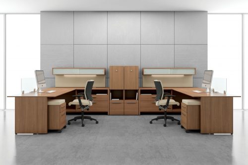 Studio shot of two L-shaped desks, with full sized windows on each side. A Graphic posture back chair is placed at each workstation.