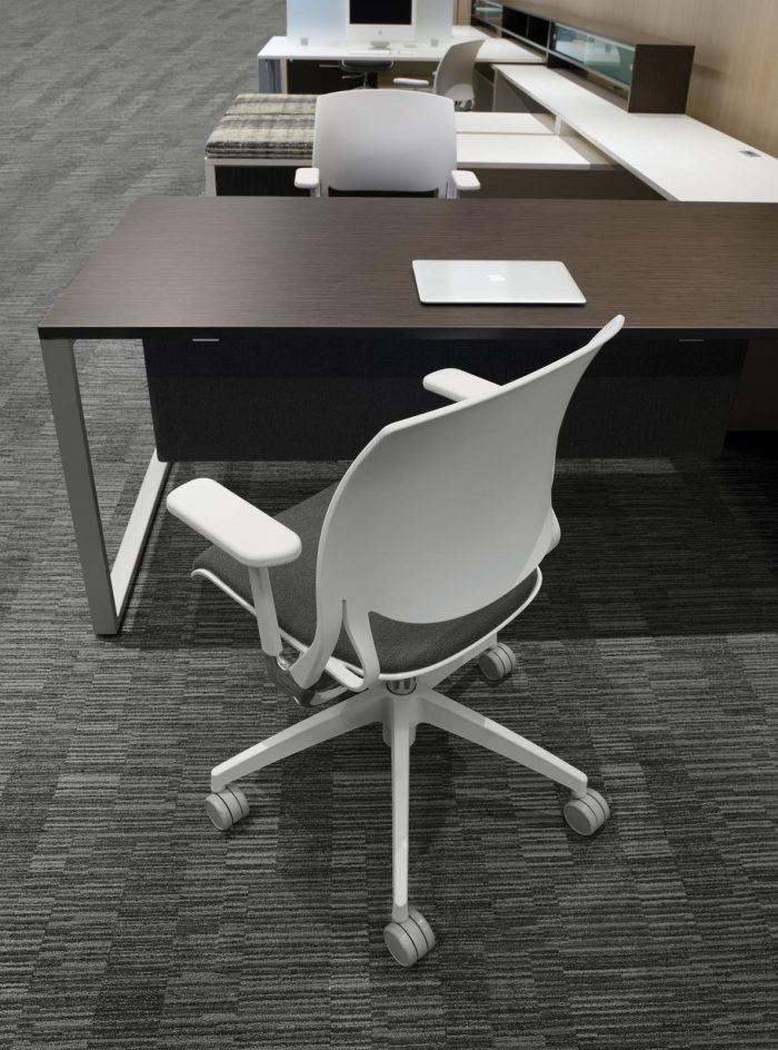 Studio photograph of the Novello office chair, placed behind a desk.