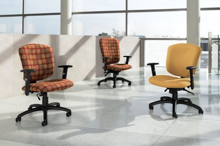 Studio shot of three Supra X office chairs on the mezzanine. A high backed and the medium backed model chair has a red circle pattern fabric on the cushions, with another chair nearby with a gold cushion.