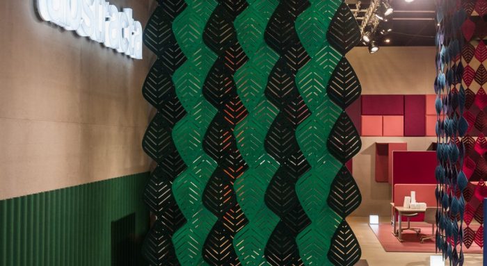 Studio shot of two sets of Airleaf acoustics forming partitions for interiors. One wall uses a mix of green and black Airleaf pieces. Towards a guest seating area, a corner is formed by Airleaf acoustics in red and blue colors.