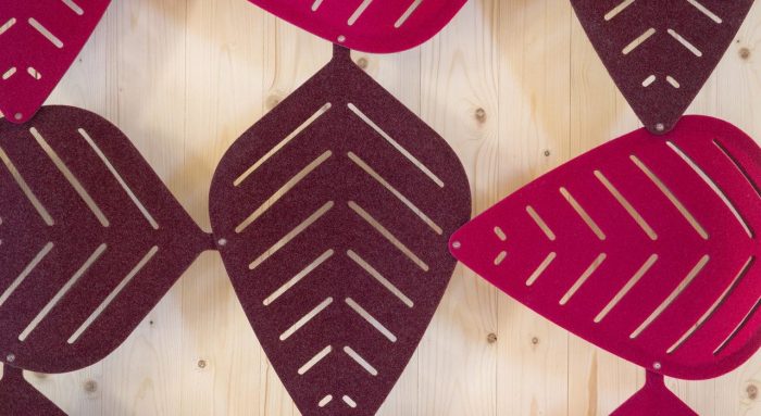 Studio shot of magenta shaded Airleaf acoustics along a wall, up close.