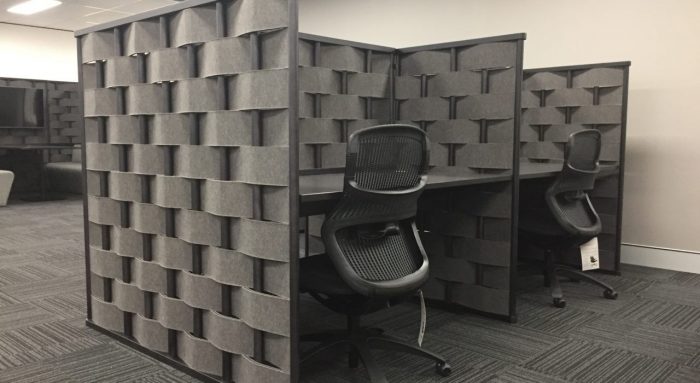 Studio shot of Bower privacy screening, showing two work stations side by side. Each desk has a new chair placed in front.