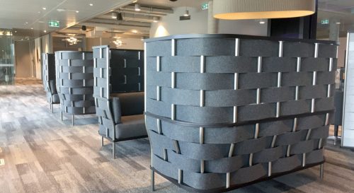 Studio shot of Bower screening wrapping two closed in seating areas of an office. Each screen wraps a comfortable couch, with each one facing one another within the area.