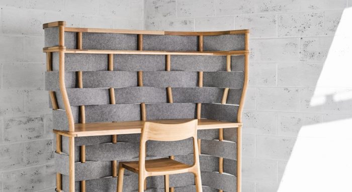 Studio shot of Bower privacy screening on a single workstation. This desk has been placed in the corner and has wooden accents to match the desk and chair.