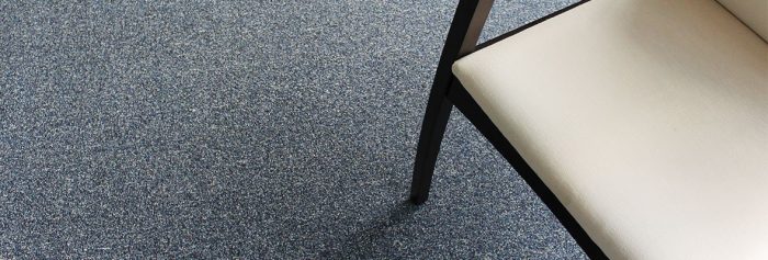 Overhead perspective view of a black legged chair resting on Passages carpeting.