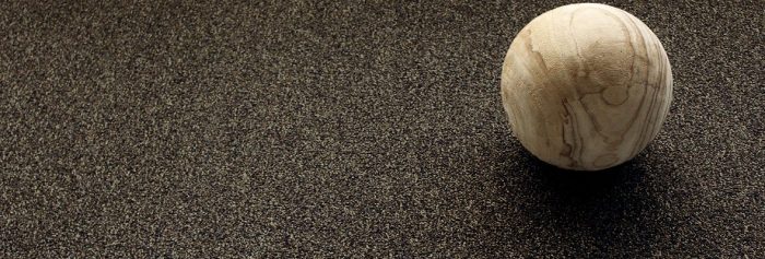Close up photo of a spherical sculpture resting on Passages carpeting.
