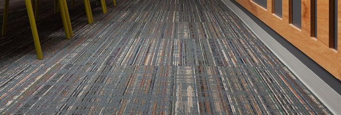 Studio shot taken in the back of a large office space, with Relativity carpeting directing you forward. A wooden rack has been mounted to this back wall.