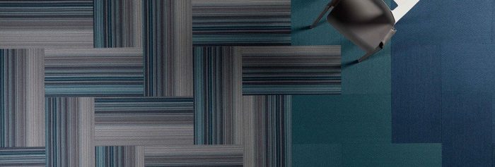 Studio shot of Umbra II carpeting from overhead. The herringbone pattern meets with other solid color carpeting.