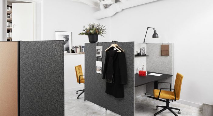 Studio shot of dB privacy screening along a cubicle row. The dB screens are done in light and dark greys, with a golden cushioned chair at each station.