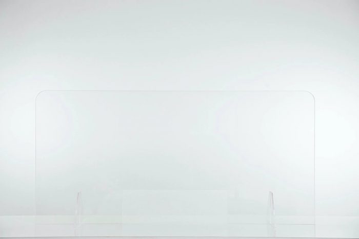 A large Counter Shield Lite screen placed on a table. One barely notices the screen as it fades into the light walls behind.