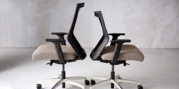 Two RunII chairs, on a grey carpet, placed with their seat backs to eachother. The high-back Run II is on the left, and the mid-back chair is on the right.