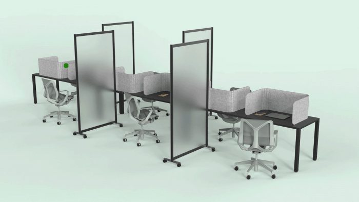 A long wooden table, set up for an office. Each work area is divided with a Hide privacy screen, with the laptop closed in front of it. Each middle seat (of each side of the table) has the Split semi-clear full length privacy screen.